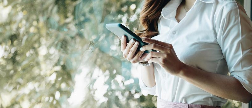 Close up hand of woman using smartphone, texting text message, hipster touch screen on smartphone light bokeh, girls using in hands cellphone close up, online internet.