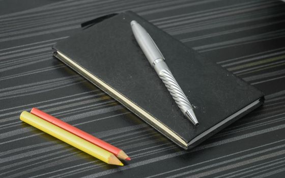 Pen and notebook on office table. Table top view. Corporate business background.
