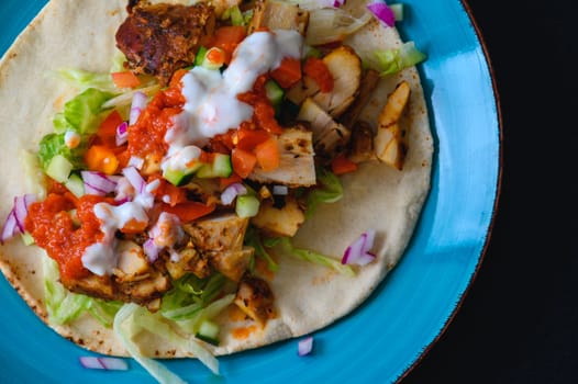 Chicken doner kebab, Turkish style doner kebab sandwich on homemade pita bread with fresh salad and homemade chili sauce and garlic yogurt sauce.