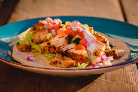 Chicken doner kebab, Turkish style doner kebab sandwich on homemade pita bread with fresh salad and homemade chili sauce and garlic yogurt sauce.