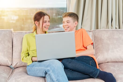 Happy kids on couch using gadget. Watching something online on computer together with family. Rest at home.