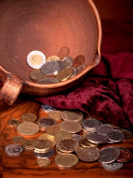 Money of different countries is combined in clay bowl