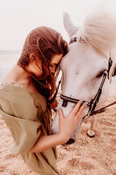 A white horse and a woman in a dress stand on a beach, with the sky and sea creating a picturesque backdrop for the scene