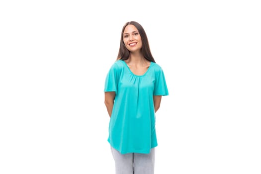 portrait of a pretty young caucasian brunette woman with long hair in a blue t-shirt on a white background with copy space.