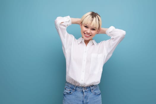 young cute blond fashionable woman with short haircut is dressed in a white shirt and jeans. casual wear concept.