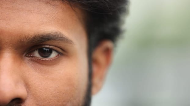 Half face of a serious man, male eye.