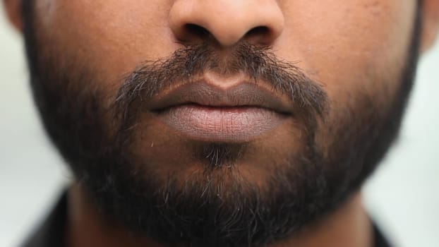 mouth man with unshaven facial hair stubble and serious expression close up