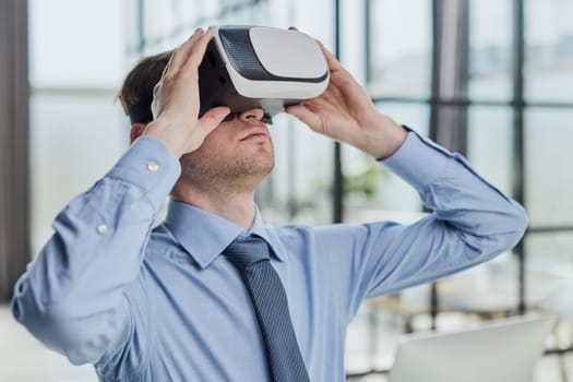 young man testing VR glasses or goggles sitting in the office room