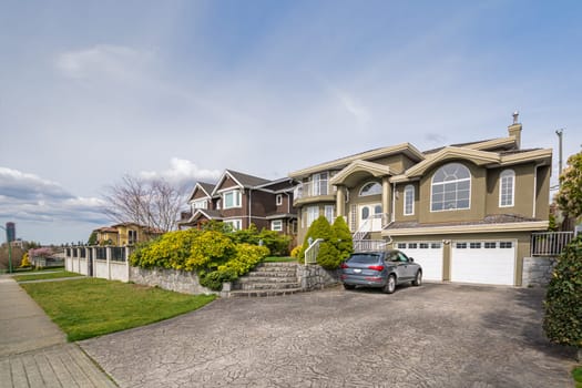 Luxury residential houses with a car parked in front on cloudy day in Vancouver, Canada