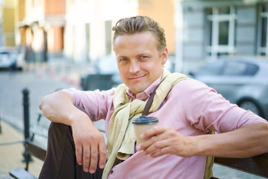 Street food concept of man enjoying tasty cup of coffee on bench outdoors. Aroma and flavor of coffee add to sensory experience of urban delight. Man's relaxed posture create sense of ease and leisure. . High quality photo