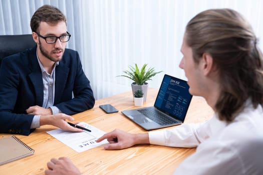 Job candidate engaging conversation with interviewer during job interview. Job applicant present work experience and qualification by digital resume on laptop and CV paper to HR manager. Entity