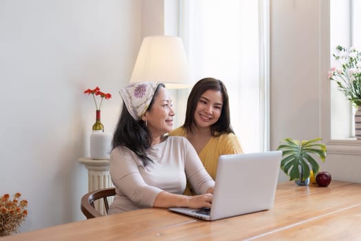 Cheerful two generation women family old senior mother and smiling young adult girl talking in living room at home.