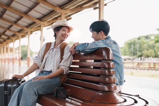 Asian couple at railway station have happy moment. Tourism and travel in the summer.