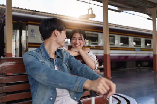 Asian couple at railway station have happy moment. Tourism and travel in the summer.
