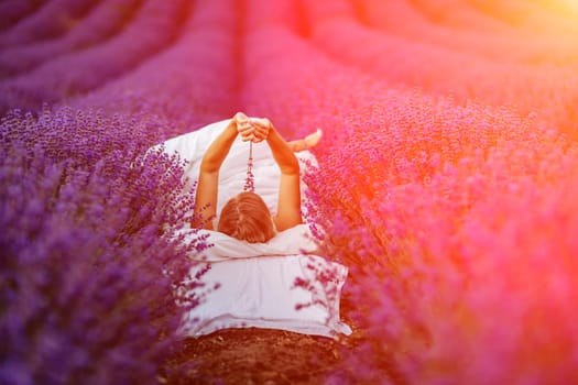 Woman lavender field. A middle-aged woman lies in a lavender field and enjoys aromatherapy. Aromatherapy concept, lavender oil, photo session in lavender.