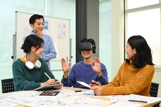 Innovation, technology and futuristic concept. Developers team brainstorming, testing virtual reality simulator glasses at meeting.