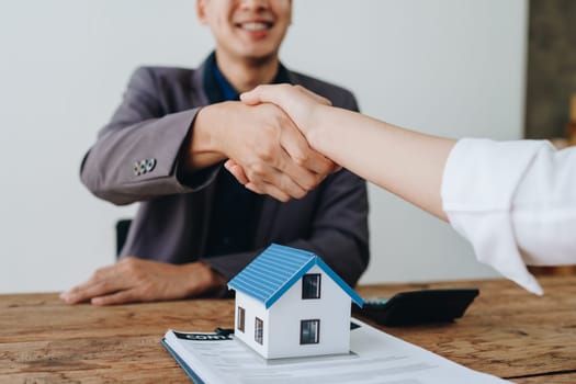 The bank's Mortgage Officers shake hands with customers to congratulate them after signing a housing investment loan agreement.