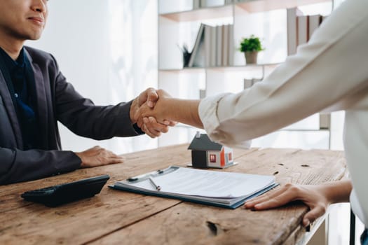 The bank's Mortgage Officers shake hands with customers to congratulate them after signing a housing investment loan agreement.