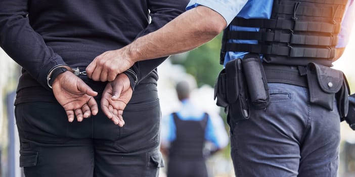 Handcuffs, crime and police with man criminal outdoors for arrested, corruption and justice. Illegal, arrest and Law enforcement with suspect for money laundering, violence or fraud, robbery or jail.