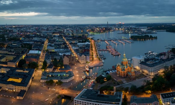 View of Uspenski Cathedral and buildings by lit streets and harbor at dawn. High quality photo