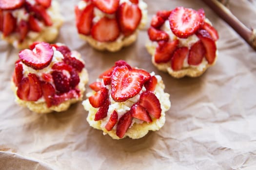 Very tasty muffins with fresh strawberries lie on kraft paper.