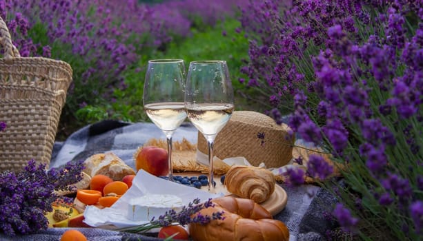 picnic in a lavender field, rest in nature, wine, fruit, berries. Selective focus