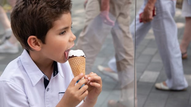 Cute child boy with a dirty face eats ice cream, the child enjoys dessert on a walk in the park, High quality photo