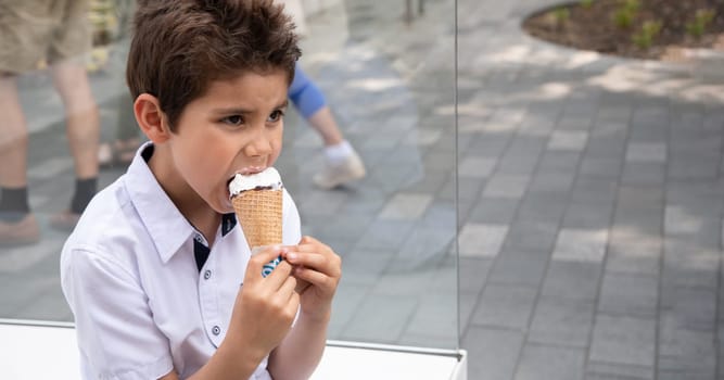 Cute child boy with a dirty face eats ice cream, the child enjoys dessert on a walk in the park, High quality photo