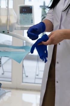 Dentist putting on gloves before starting working on patient's mouth, Woman doctor. Woman dentist. Dentist clinic. Dentist's office. Dental clinic