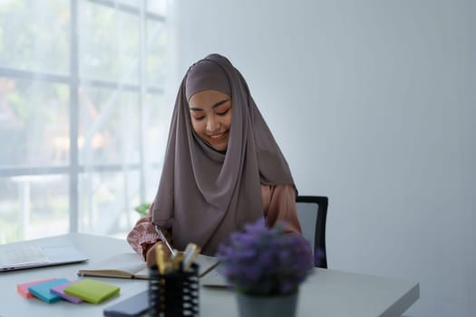 financial, Planning, Marketing and Accounting, portrait of Muslim woman employee checking financial statements using documents and calculators at work.