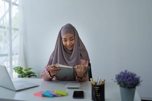 financial, Planning, Marketing and Accounting, portrait of Muslim woman employee checking financial statements using documents and calculators at work.