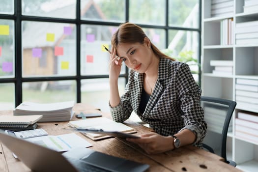 Portrait of business owner, woman using computer and financial statements Anxious expression on expanding the market to increase the ability to invest in business.