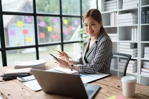 Young asian female work with financial papers at home count on calculator before paying taxes receipts online, planning budget glad to find chance for economy saving money, audit concepts