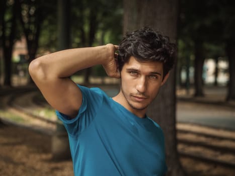 Three quarters shot of one handsome young man in urban setting wearing blue polo shirt