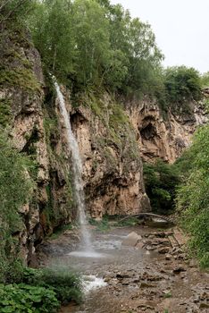 Beautiful nature. Mountain waterfall surrounded with trees and fog