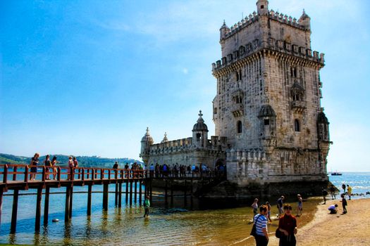 Lisbon, Portugal- 19 May, 2018: Tourists visiting Belem Tower in a low tide day in Lisbon in a sunny day of Spring.