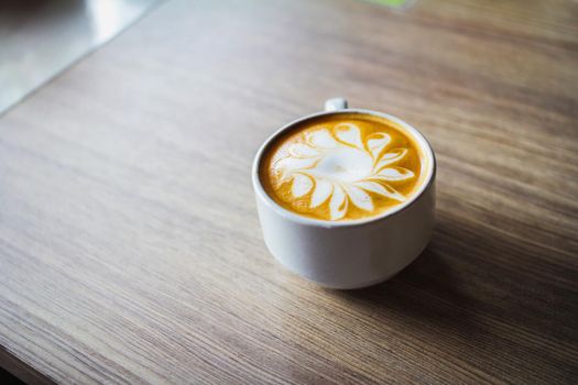 Latte art coffee cup on wood table