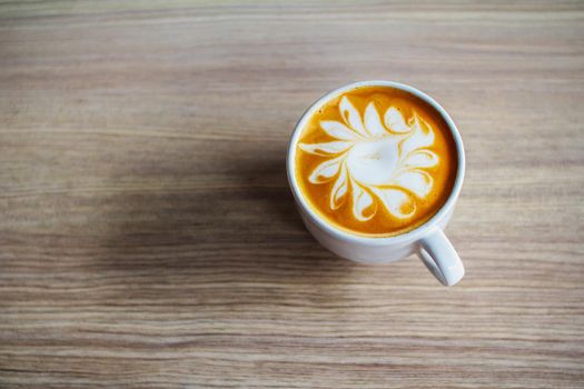 Latte art coffee cup on wood table