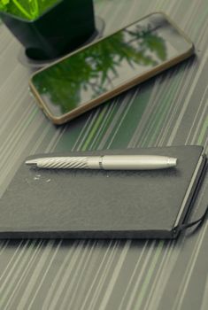 Pen and notebook on office table. Table top view. Corporate business background.