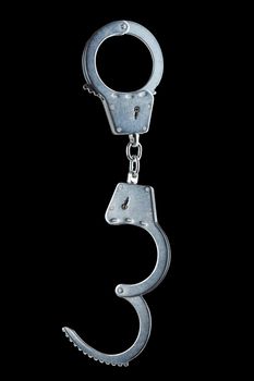 real zinc plated steel police handcuffs half-opened hanging vertically, isolated on black background.