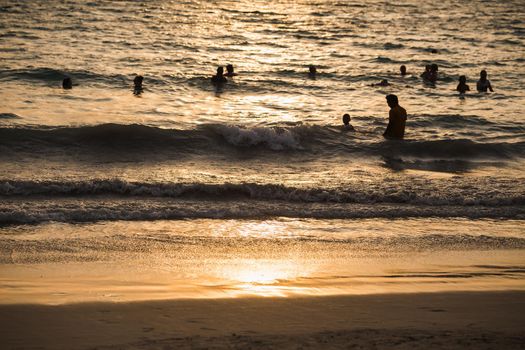 silhouette people wave sea beach sunset