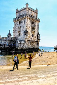 Lisbon, Portugal- 19 May, 2018: Tourists visiting Belem Tower in a low tide day in Lisbon in a sunny day of Spring.