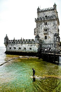 Lisbon, Portugal- 19 May, 2018: Tourists visiting Belem Tower in a low tide day in Lisbon in a sunny day of Spring.