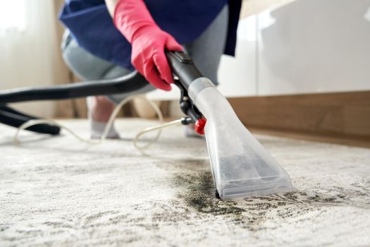Close-up Of A Person Cleaning Carpet With Vacuum Cleaner