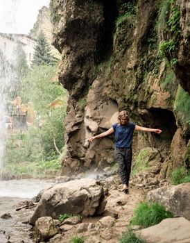 Beautiful nature. Small human watching at beautiful mountain waterfall