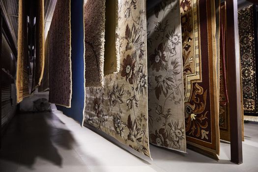 Different carpets hanging on racks. Professional carpet cleaning and drying.