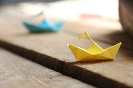 Summer travel concept. Paper boats on vintage wooden background.