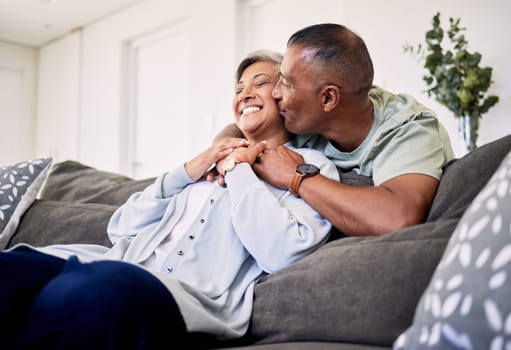 Hug, surprise kiss and happy elderly couple bonding, relax and spending time together, smile and enjoy home retirement. Living room, love or senior man, old woman or sweet people with marriage care.