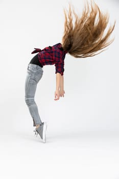 The silhouette of the girl seen in profile. The girl poses for the photo and performs a difficult acrobatics by standing on tiptoe and arching her back. The girl's hair can be seen moving and flying in the air.