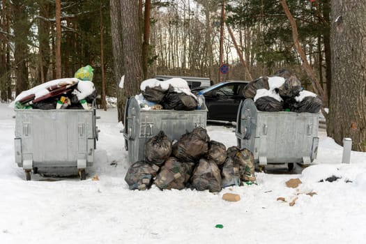 overflowing garbage containers on the site around which garbage and bags of waste are scattered. Poor performance of public utilities.